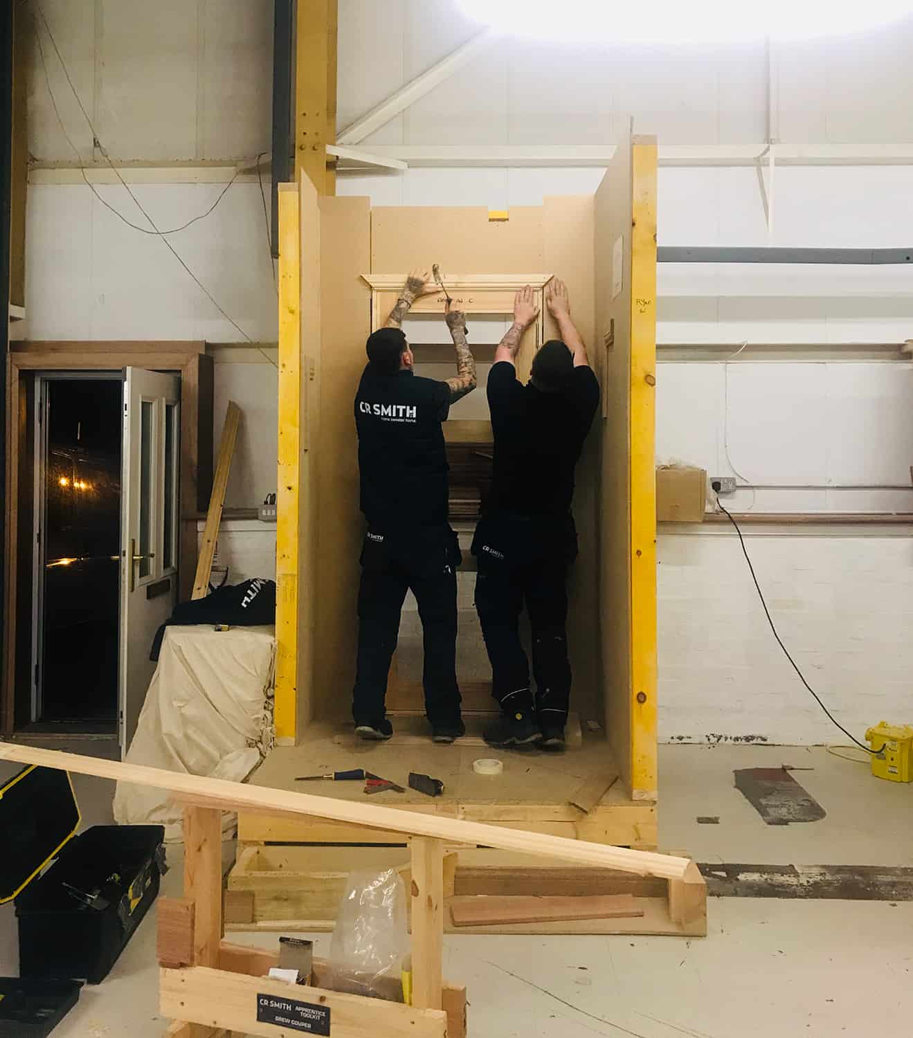 Two CR smith employees fitting window frame