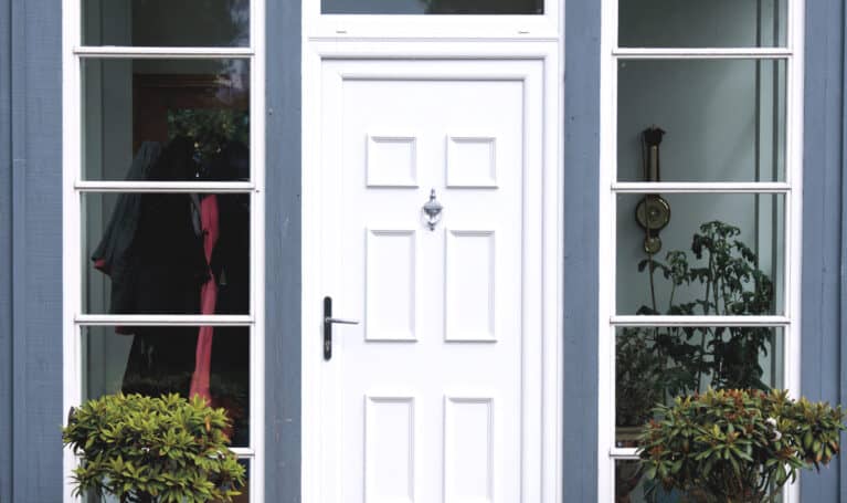 External view of white uPVC front door with urn knocker and lever handle