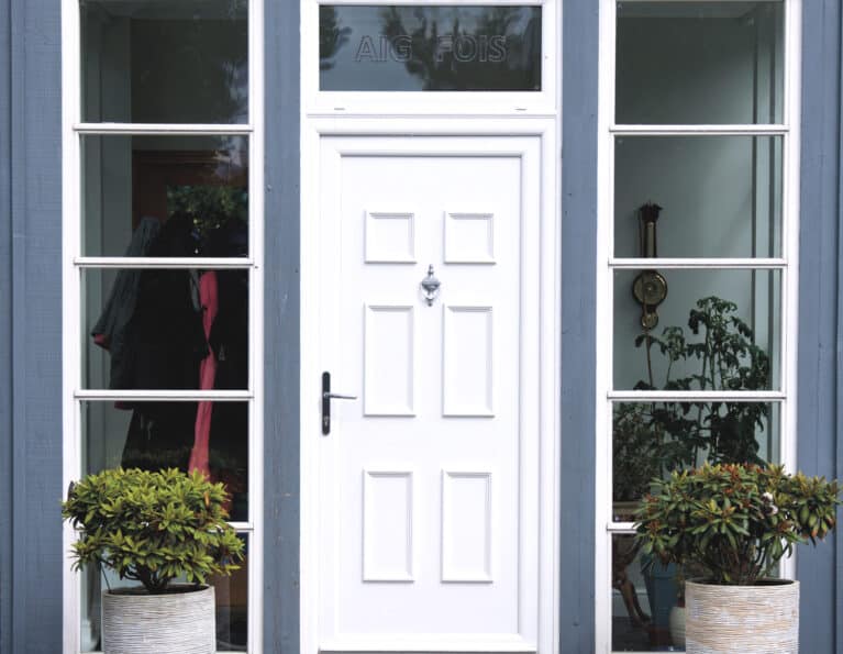 External view of white uPVC front door with urn knocker and lever handle
