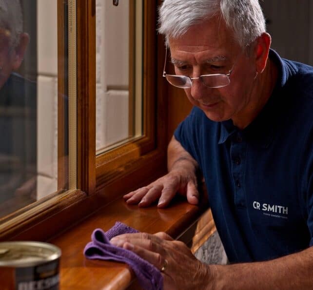 CR Smith member of staff applying wax to a window sill