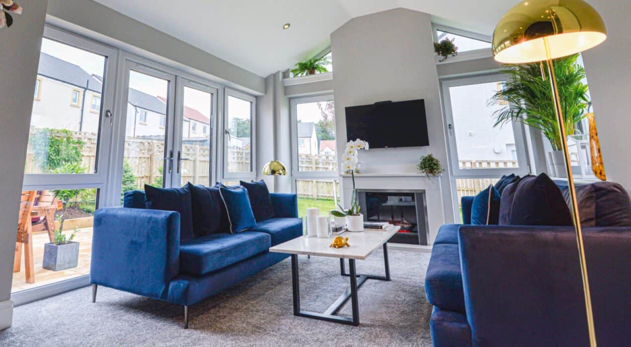 Lorimer sunroom with tilt and turn windows, french doors and blue velvet sofas