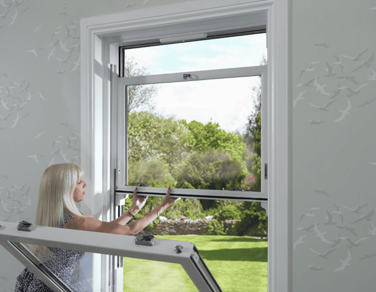 Model demonstrating how to pull down the top sash in a sliding sash window