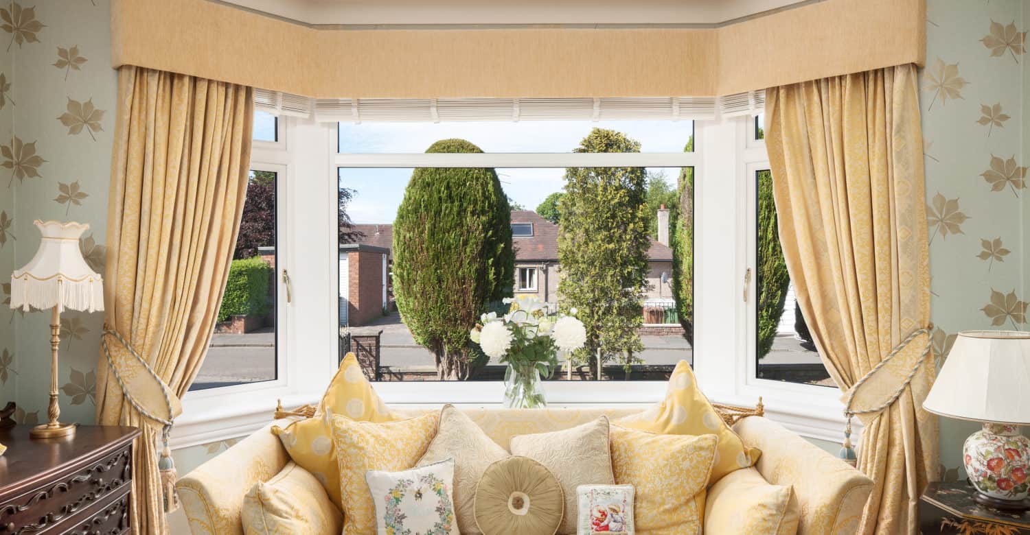 Yellow couch in front of a window