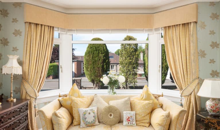 Yellow couch in front of a window