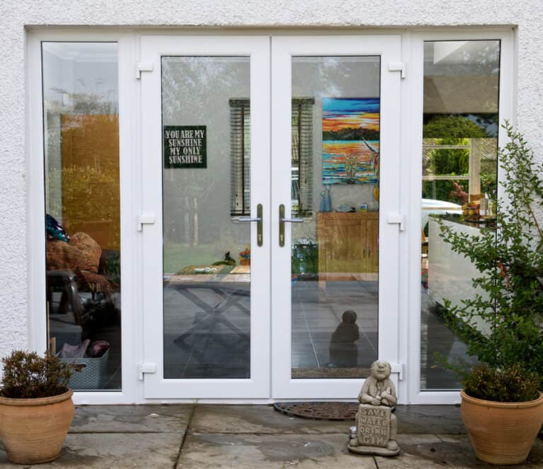 External view of white french doors and two side screens