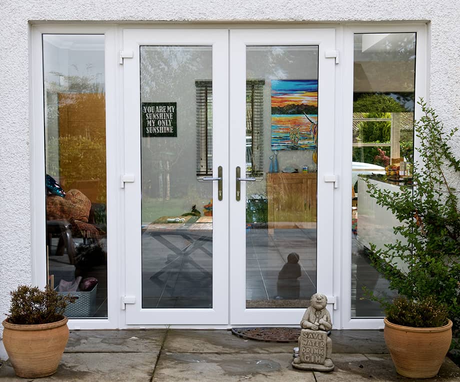 External view of white french doors and two side screens