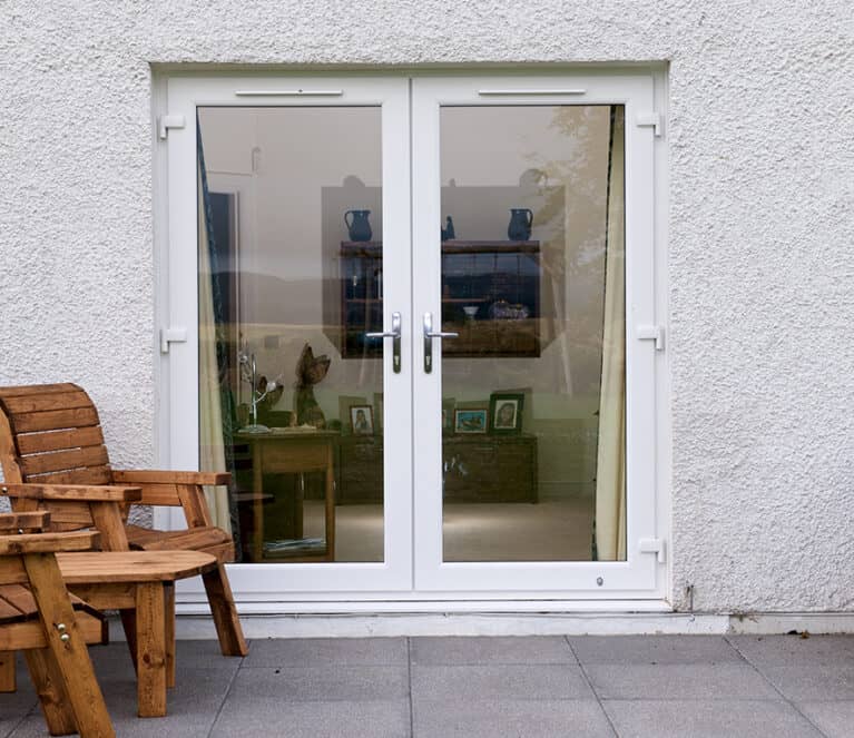 External view of white french doors with chrome lever handles