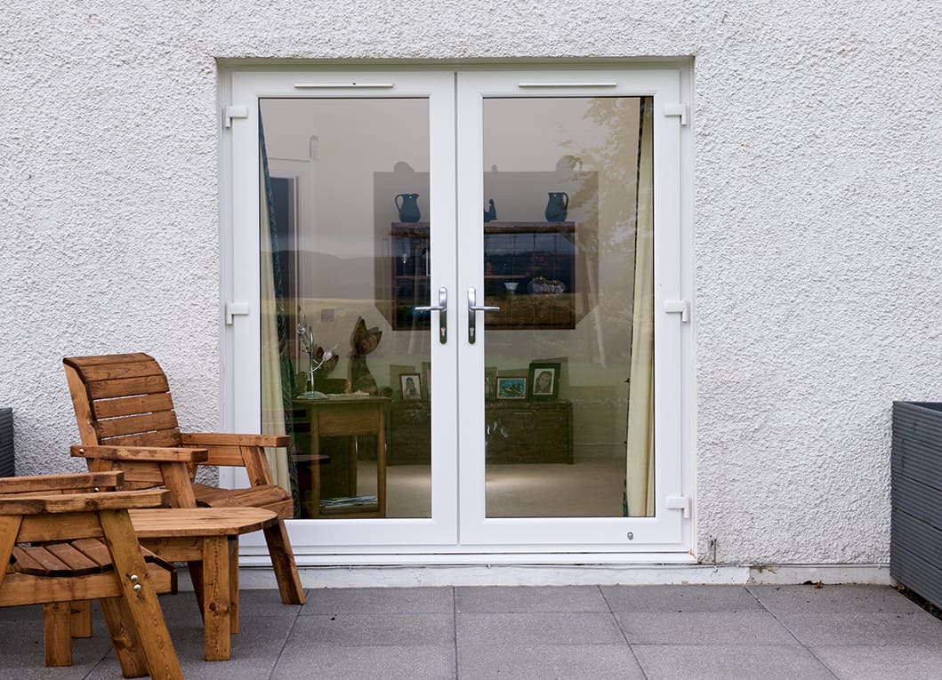 External view of white french doors with chrome lever handles