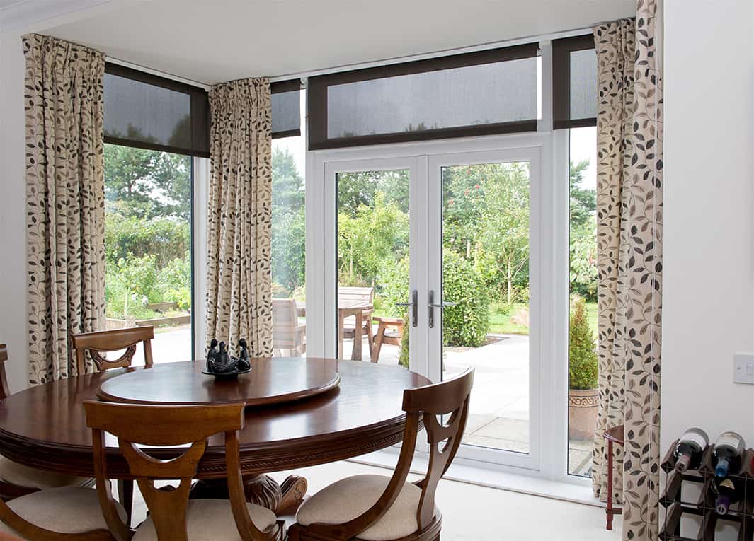 Dining room with large floor to ceiling windows and a set of french doors in white