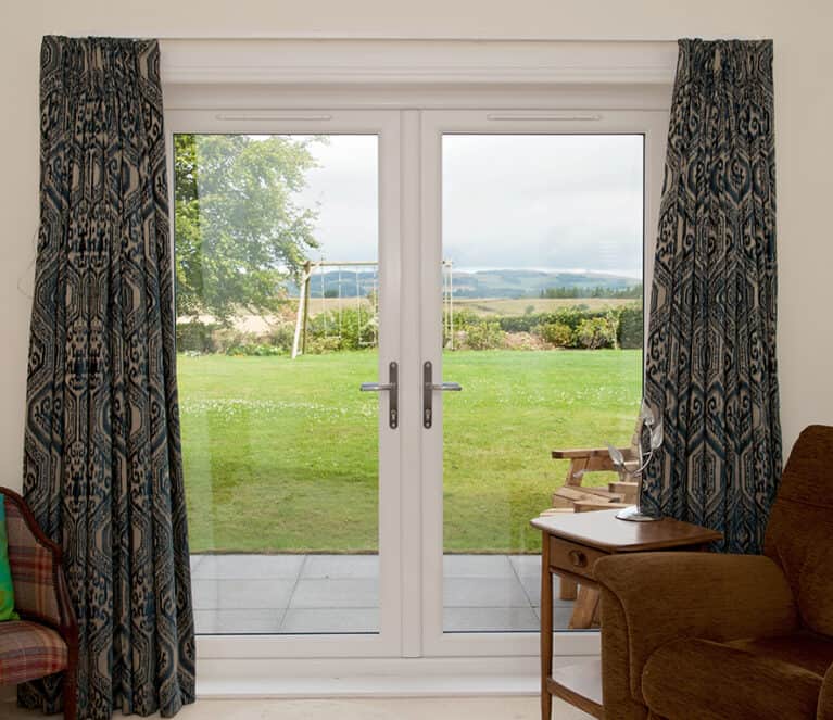 Internal view from living room of white french doors leading out to the garden