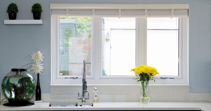 White casement window in the kitchen behind the sink