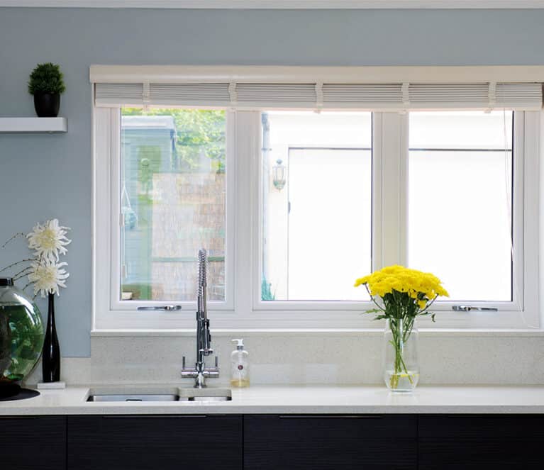 White casement window in the kitchen behind the sink