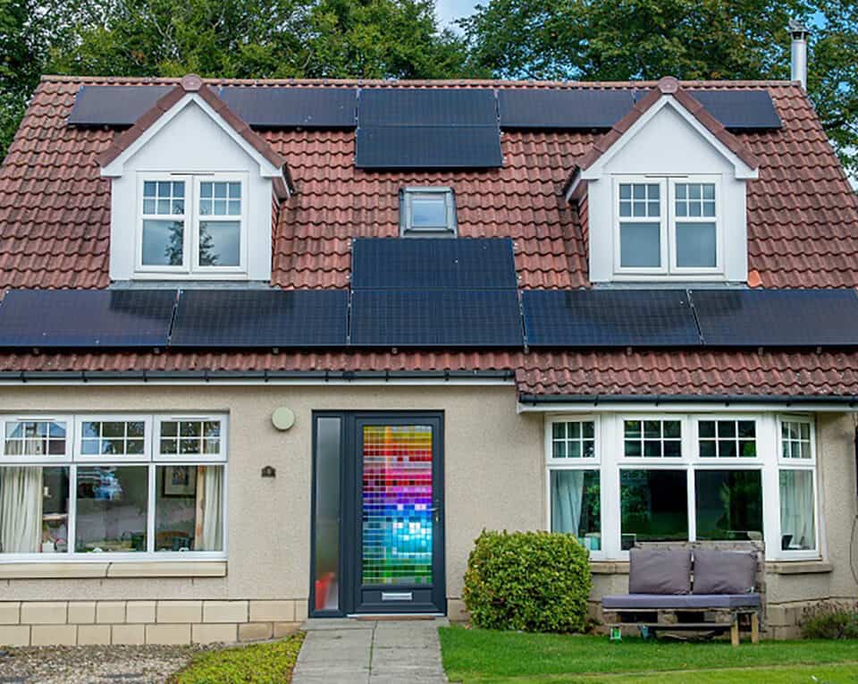 External view of home with anthracite grey front door with a multicoloured stained glass design