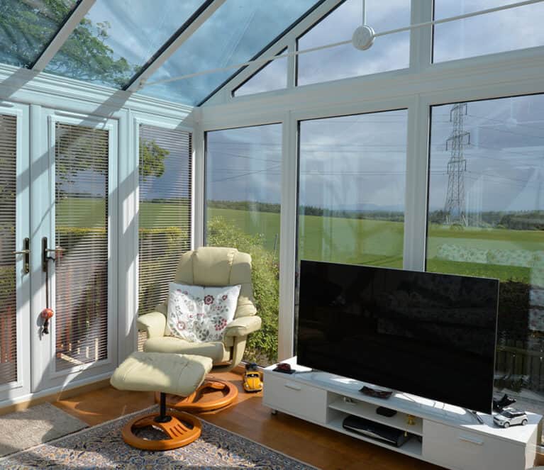 Internal view of gable front conservatory with TV stand and two chairs