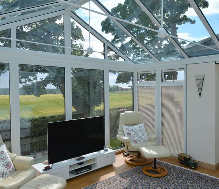 Internal view of gable front conservatory with TV stand and two chairs