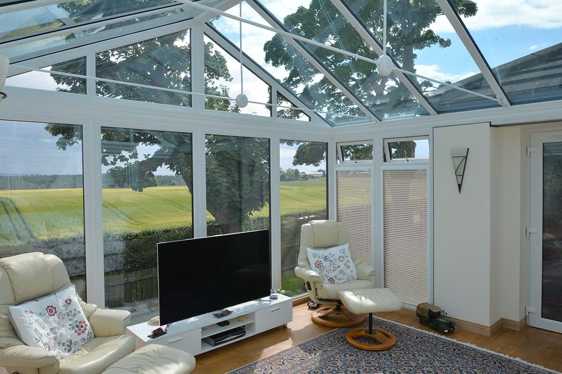 Internal view of gable front conservatory with TV stand and two chairs