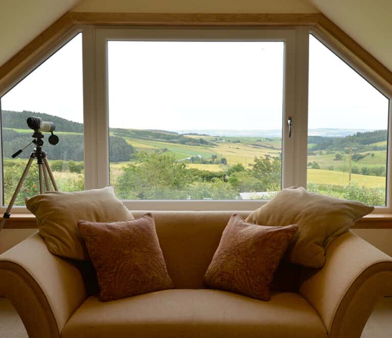 Large tilt and turn window with angled fixed panes finished with royal oak timber sills and surrounds