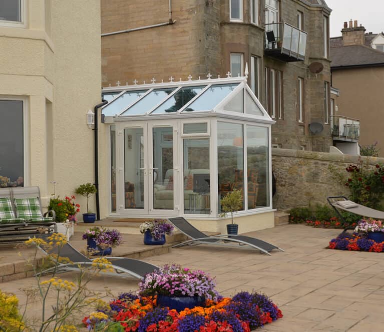 Gable front white conservatory with blue tinted smartglass roof and french doors