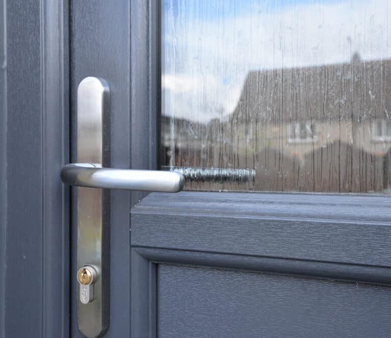 Close up of satin chrome lever handle on an anthracite grey uPVC front door