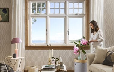 Living room with lorimer casement window and woman arranging flowers