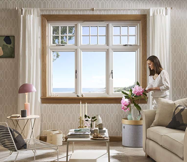 Living room with lorimer casement window and woman arranging flowers