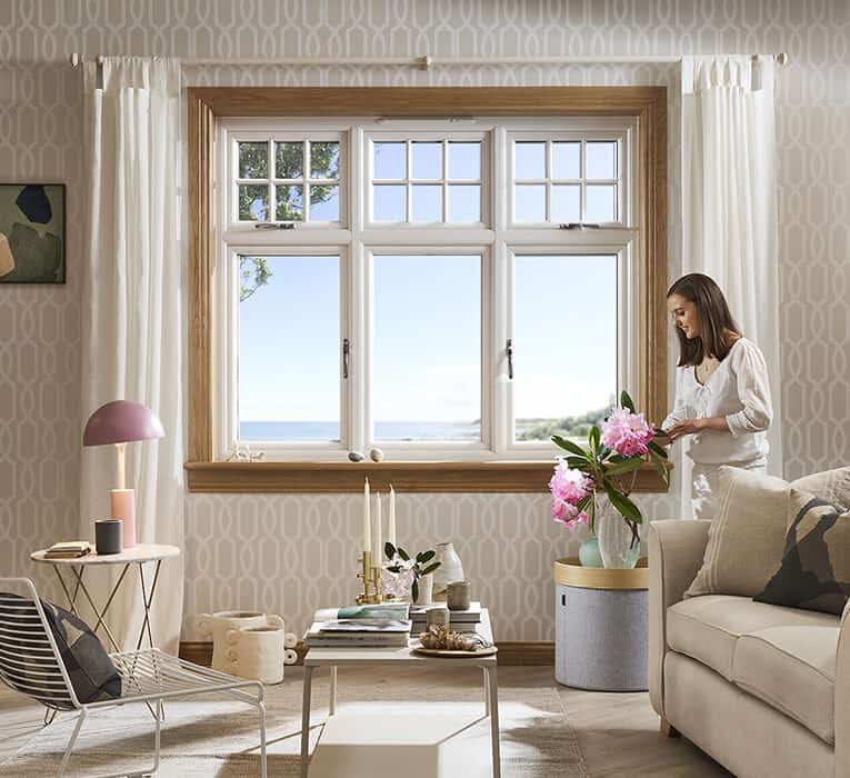 Living room with lorimer casement window and woman arranging flowers