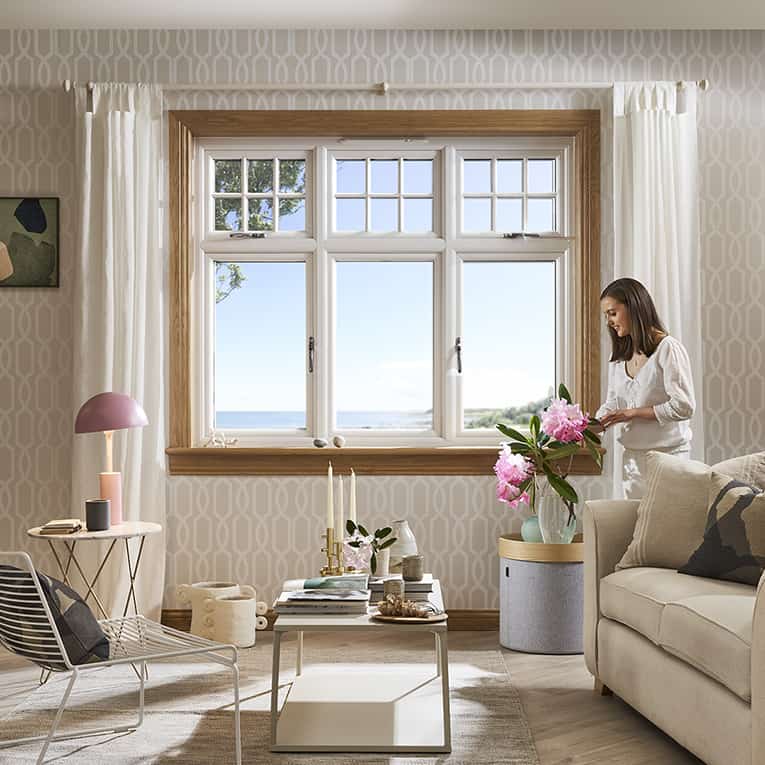 Living room with lorimer casement window and woman arranging flowers