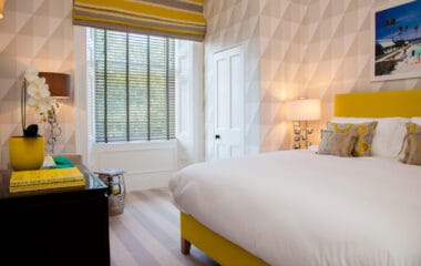 Bedroom with large window, venetian blinds and a roman blind