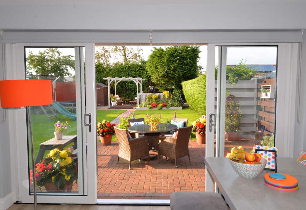 Internal view of white four part patio doors which are open to the garden