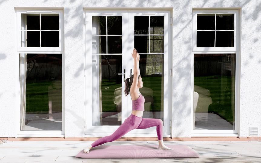 Woman practicing yoga in front of Lorimer french doors and casement windows