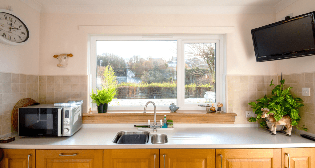 After photo of a white casement window with royal oak sills in a kitchen