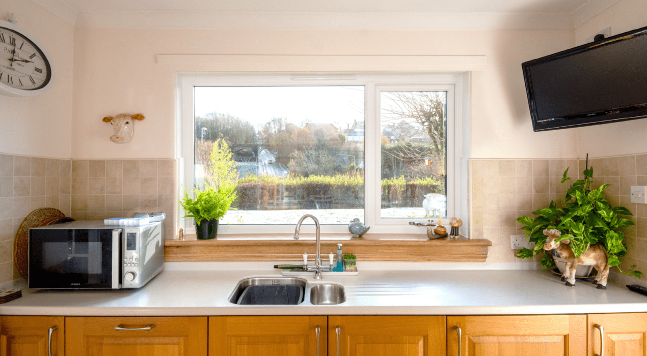 After photo of a white casement window with royal oak sills in a kitchen