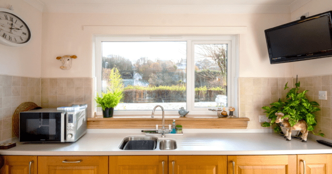 After photo of a white casement window with royal oak sills in a kitchen