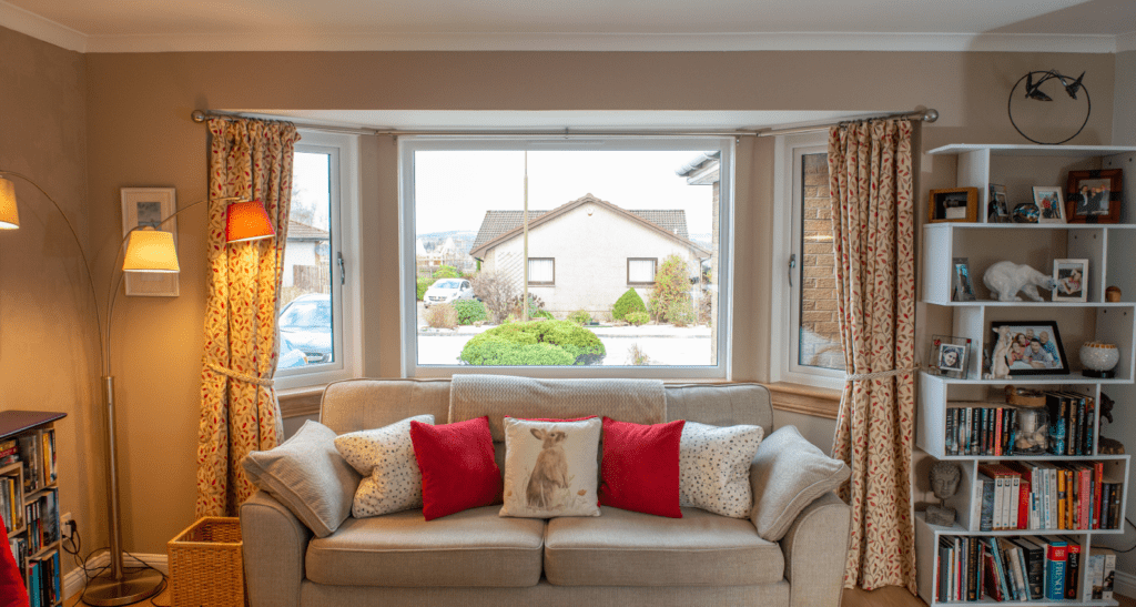 After photo of a white casement bay window in a living room