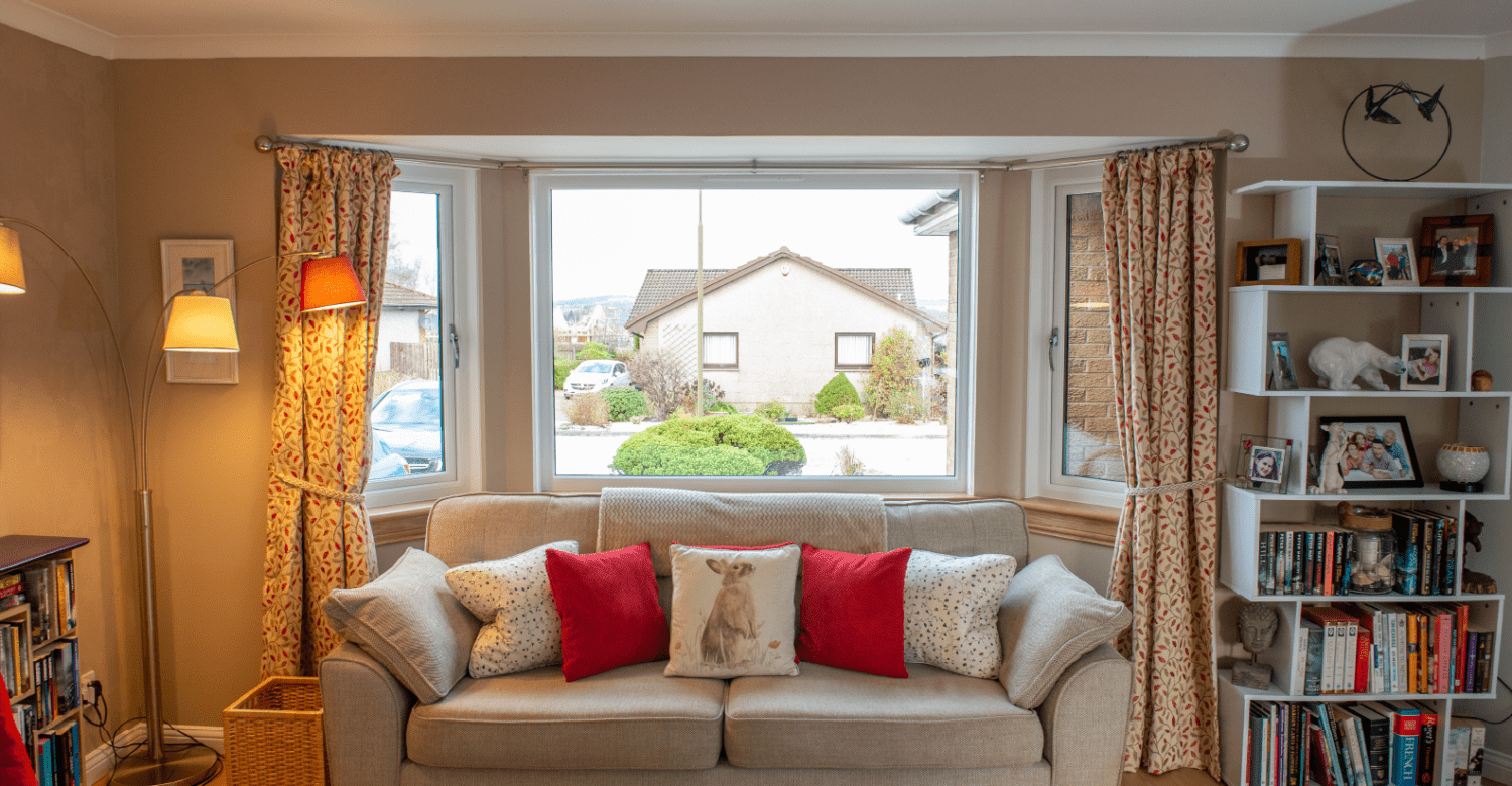 After photo of a white casement bay window in a living room