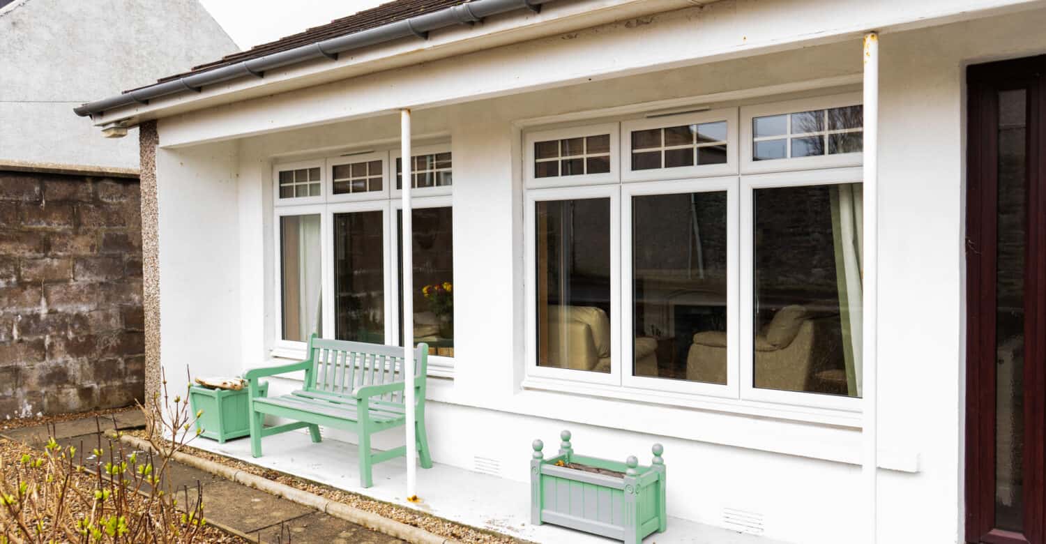 After photo of living room windows with new white casement windows installed