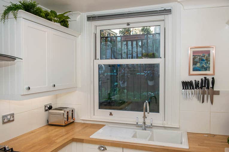 Kitchen with white uPVC sliding sash window and white sills and surrounds