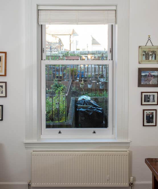 Large white sliding sash window with white window sills and surrounds