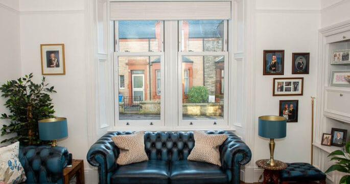 White upvc sliding sash windows in a Victorian property with white wainscot paneling