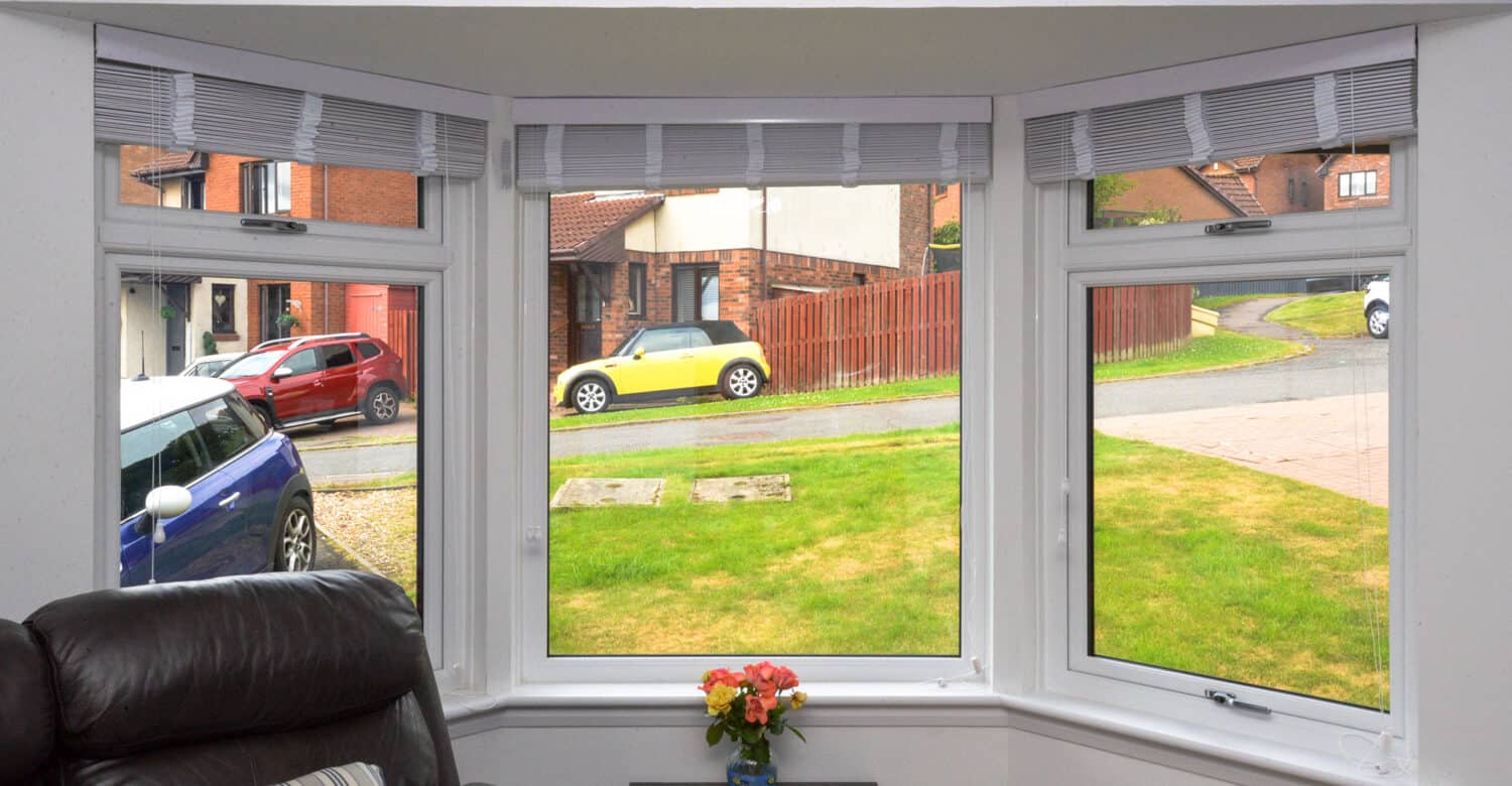 After photo of bay window with white casement windows and white sills