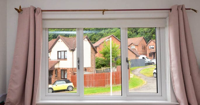 Bedroom with white casement window, white window sills and pink curtains