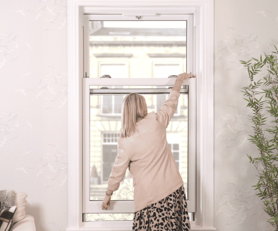 Model demonstrating how to open the bottom sash while releasing the travel restrictor on a sliding sash window