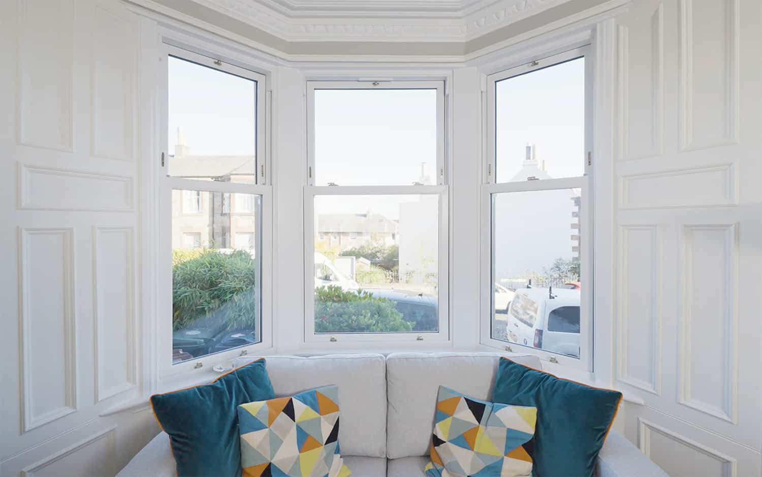 Living room bay window with white upvc sliding sash windows