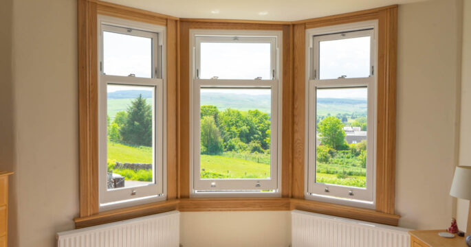 Three part bay window with new white upvc sliding sash windows. Royal oak sills and surrounds