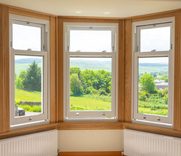 Three part bay window with new white upvc sliding sash windows. Royal oak sills and surrounds