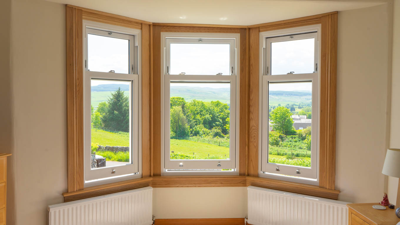 Three part bay window with new white upvc sliding sash windows. Royal oak sills and surrounds