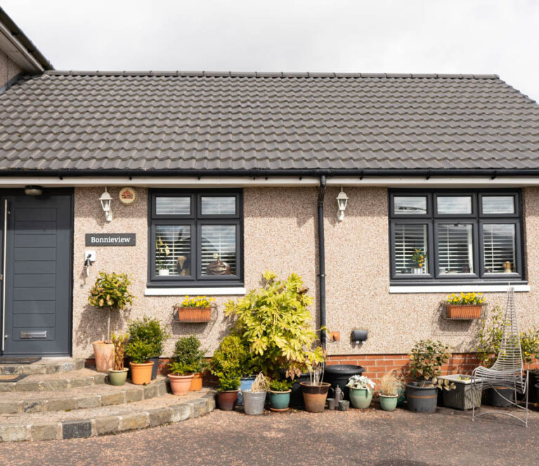 External view of property with anthracite grey front door and casement windows