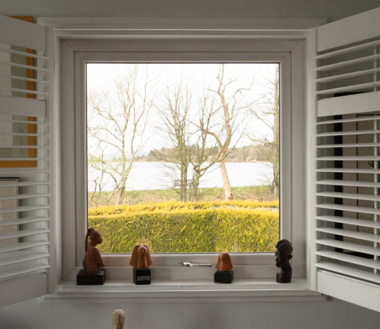 Internal view of white casement window with white shutters open
