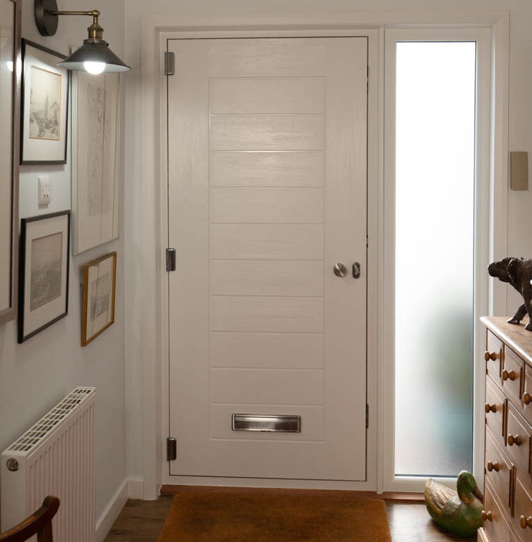 Internal view of white engineered timber front door and frosted glass side screen