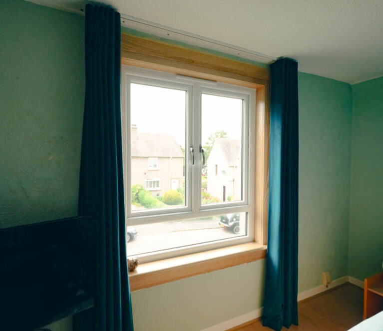 White casement window in bedroom with royal oak sills and surrounds